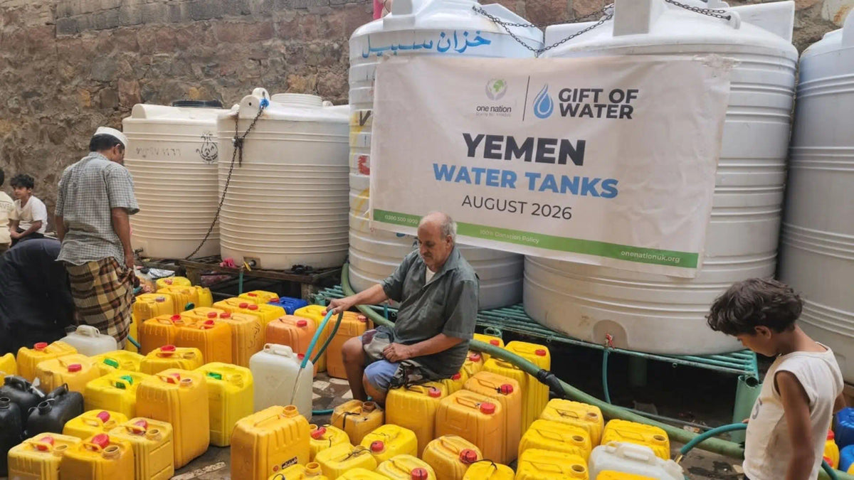 A Yemeni old man filling water through water tanks donated by Dukhni